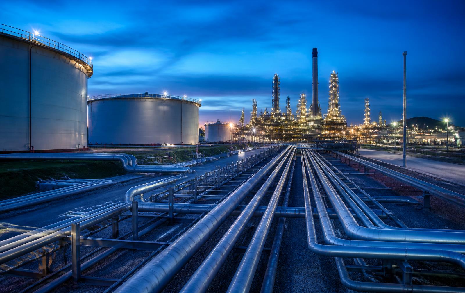 Oil refinery and fuel storage terminal with pipeline network at dusk