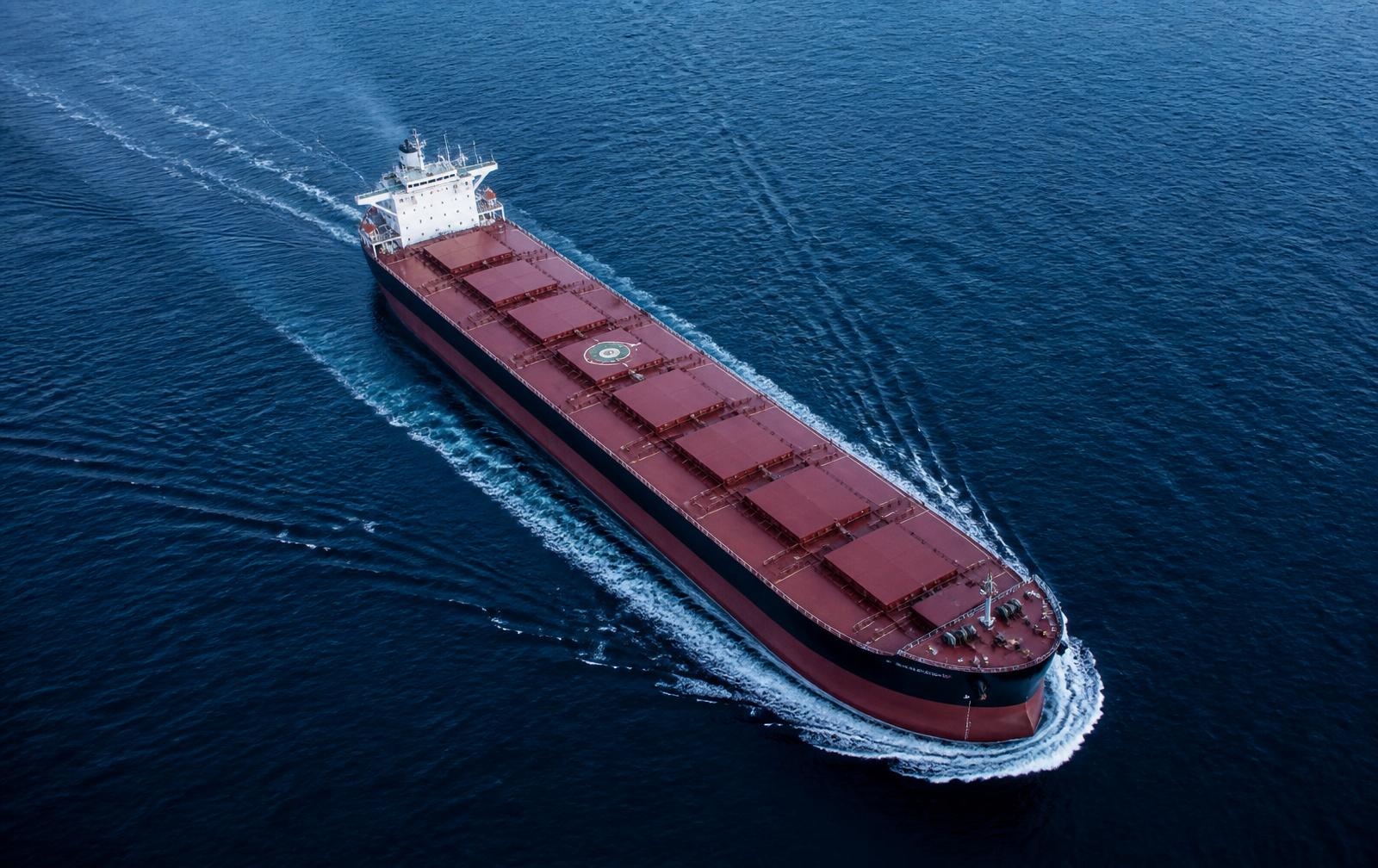 Bulk carrier vessel underway on open ocean, viewed from above